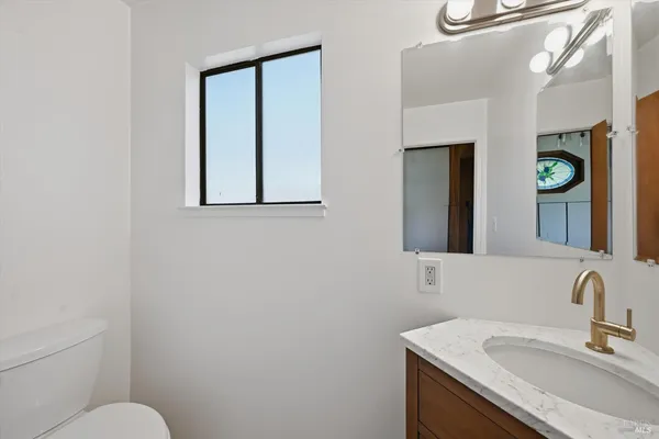 a bathroom with a sink vanity and a toilet