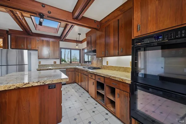a kitchen with stainless steel appliances granite countertop a stove a sink and a microwave