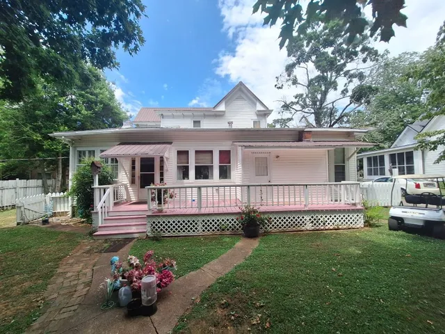 a view of a house with backyard and sitting area