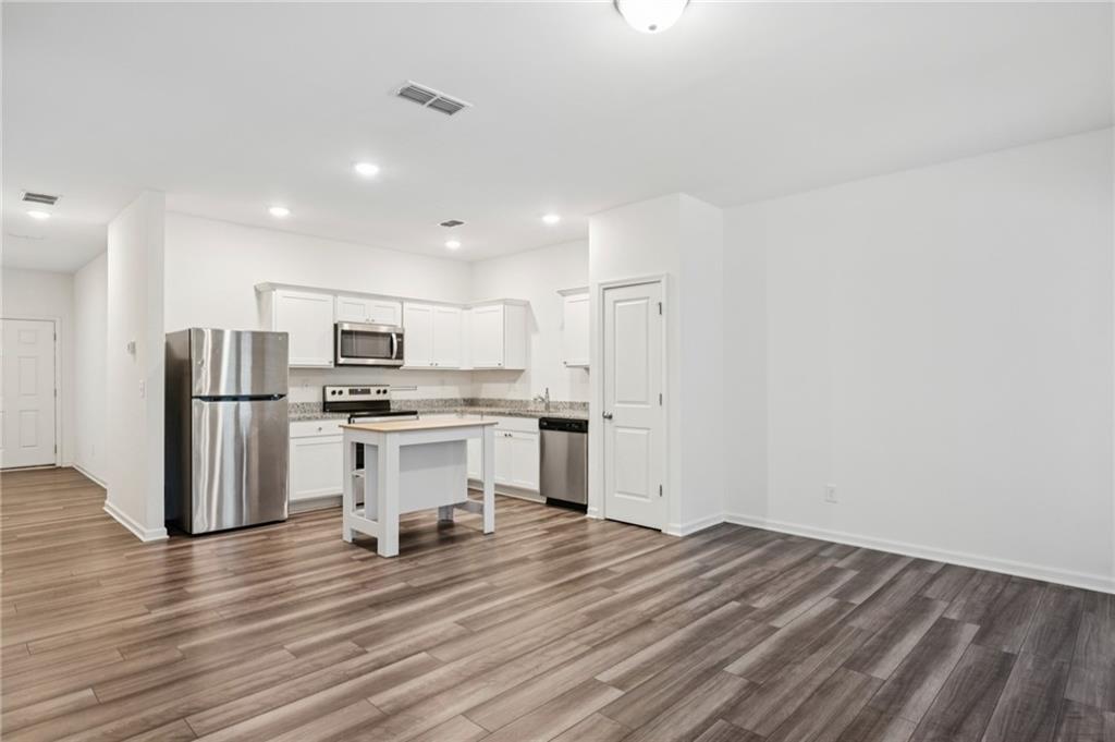 1653 Vernon Boulevard Decatur, GA 30035 - Photo 6 of 24 a kitchen with stainless steel appliances a refrigerator and wooden floor