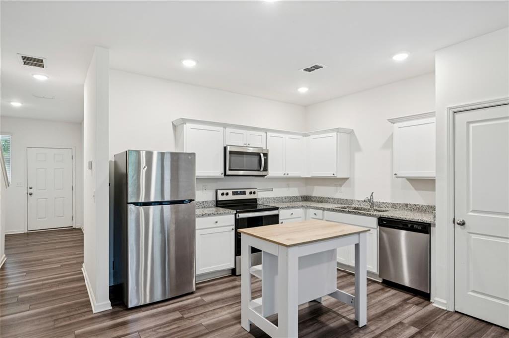 1653 Vernon Boulevard Decatur, GA 30035 - Photo 7 of 24 a kitchen with a refrigerator a microwave and cabinets
