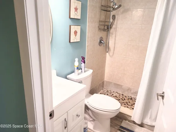 a bathroom with a sink a toilet and shower curtain