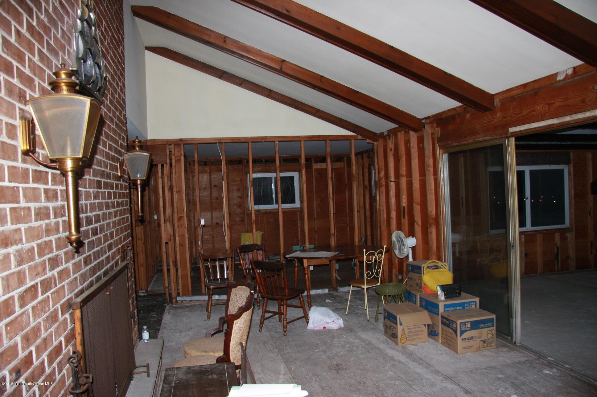 731 Drum Point Road Brick, NJ 08723 - Photo 8 of 11 a view of a porch with chairs and floor to ceiling window