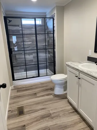 a bathroom with a granite countertop toilet and a sink