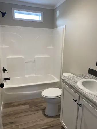 a bathroom with a granite countertop toilet and a sink