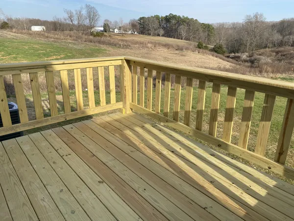 a view of a balcony with wooden floor and fence