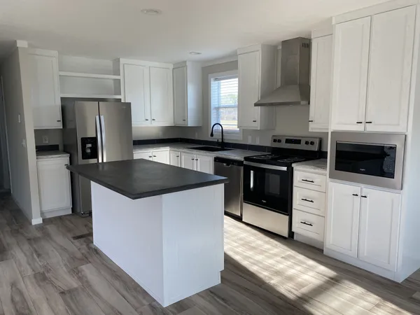 a kitchen with stainless steel appliances a stove a sink and a refrigerator