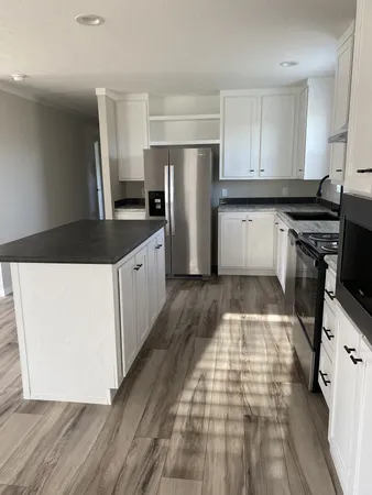 a kitchen with a sink a refrigerator and cabinets