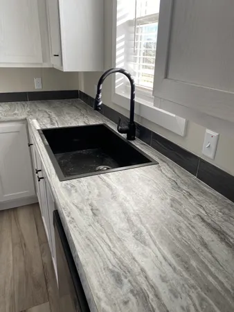 a kitchen with a sink a stove and cabinets