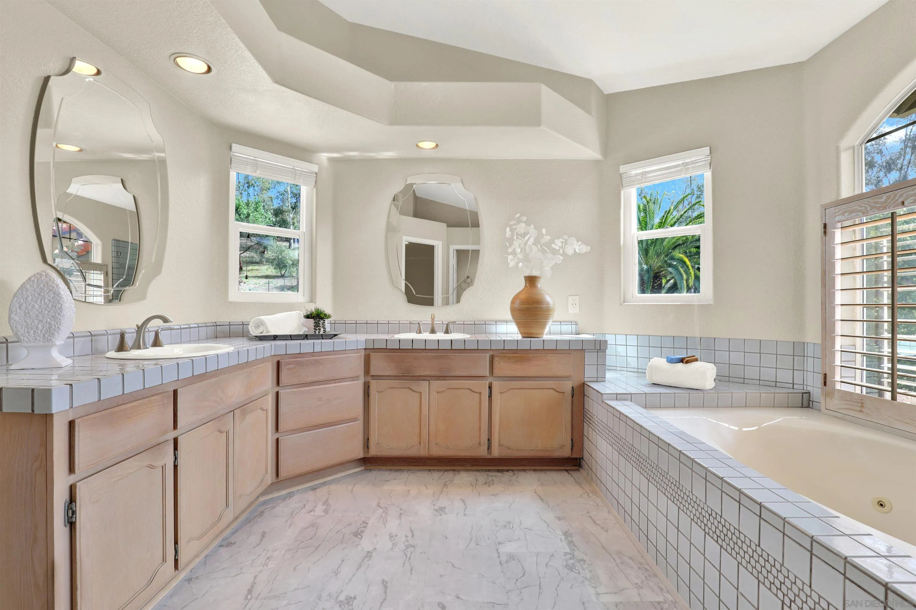 13901 Carriage Road Poway, CA 92064 - Photo 20 of 37 a bathroom with a granite countertop double vanity sink a large mirror a bathtub and a window