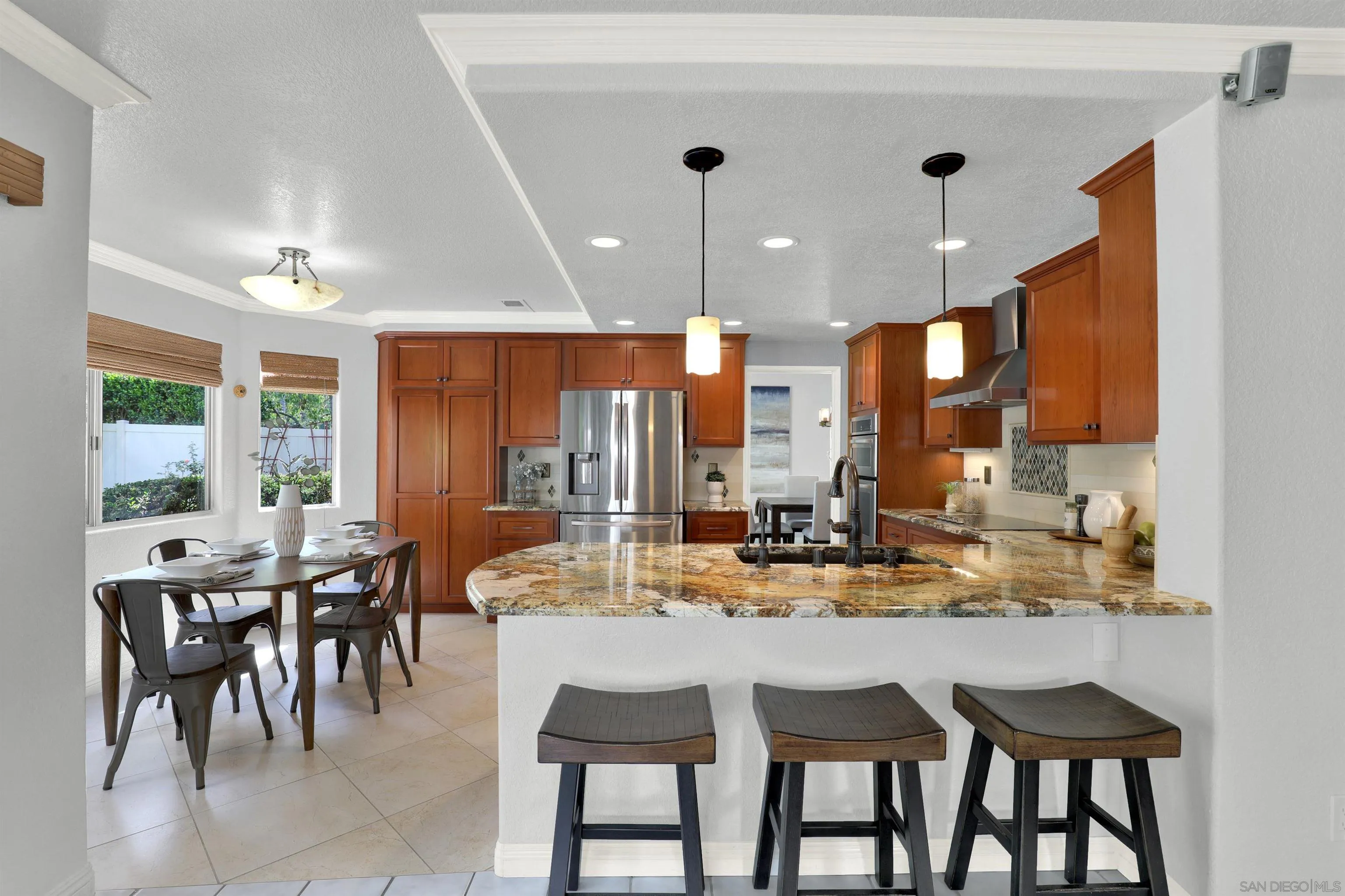 13901 Carriage Road Poway, CA 92064 - Photo 9 of 37 a kitchen with a dining table chairs and white cabinets