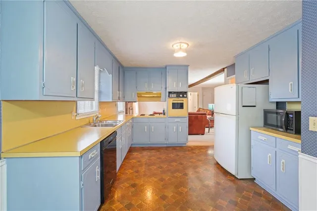 a kitchen with granite countertop a refrigerator and a stove top oven