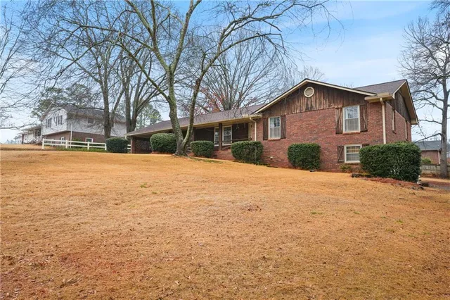 a front view of house with yard and trees around
