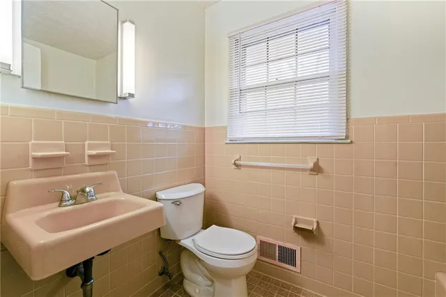 a bathroom with a sink a toilet and a mirror
