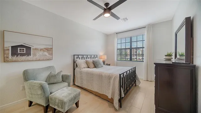 a bedroom with a bed large mirror and a dresser