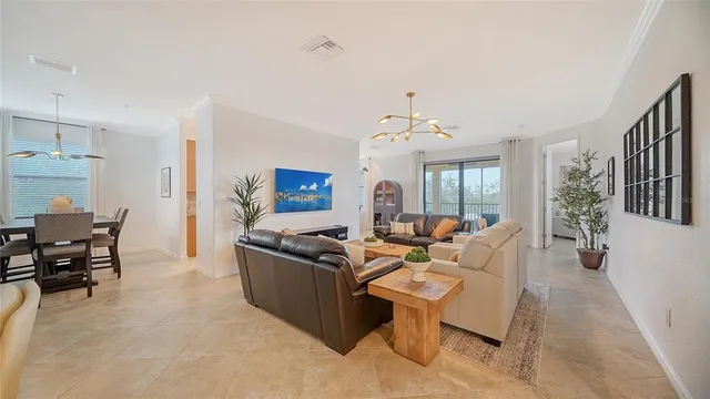 a living room with furniture a large window and a chandelier