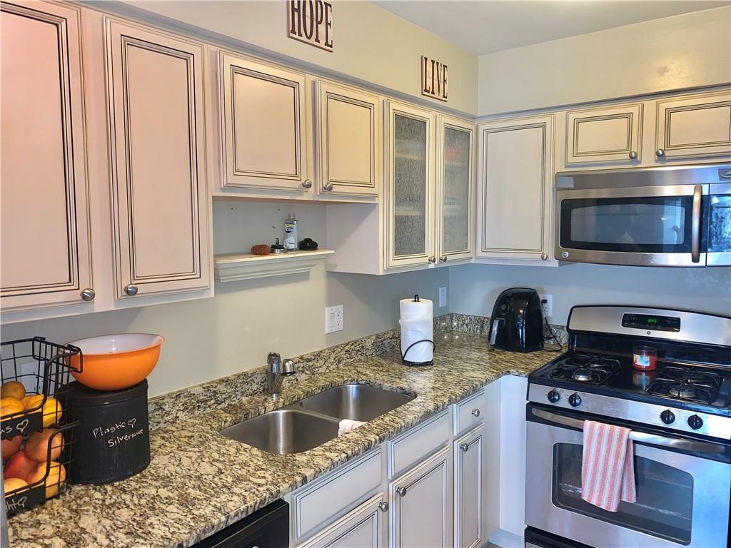 Kitchen has a view of the Living Room, Granite CounterTops, Stainless Steel Appliances