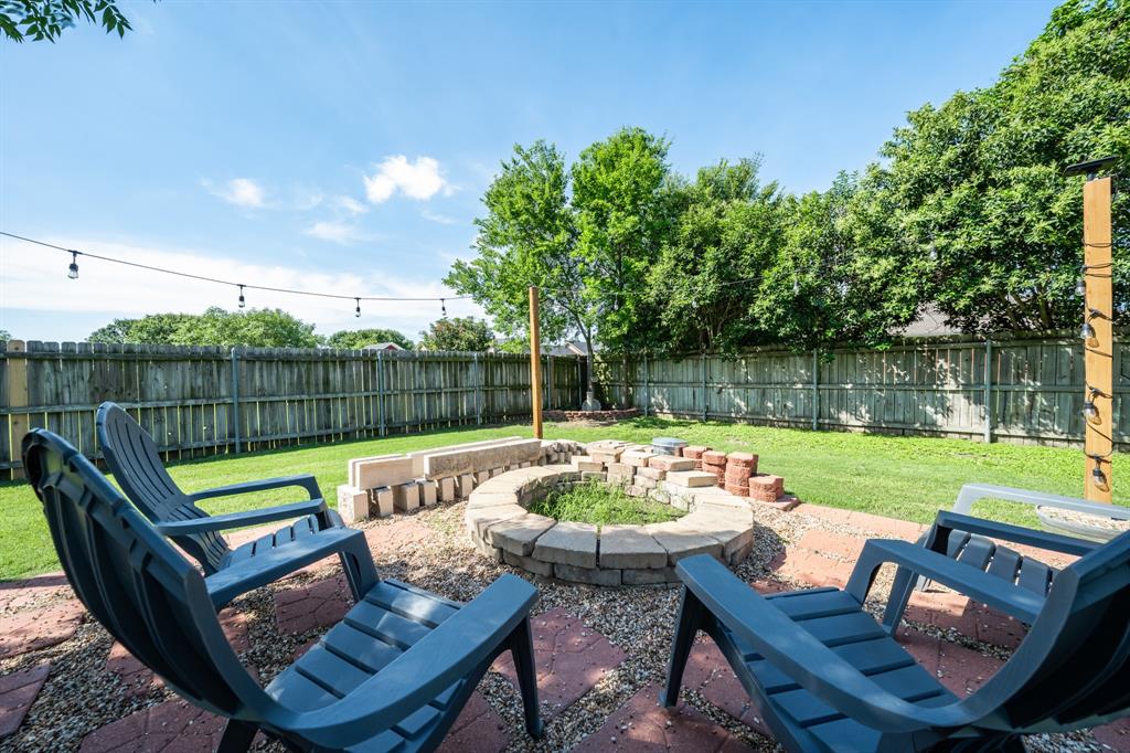 10512 Whitney Trace Drive Waco, TX 76708 - Photo 9 of 39 Outdoor gathering area featuring a stone fire pit, brick patio, and string lighting
