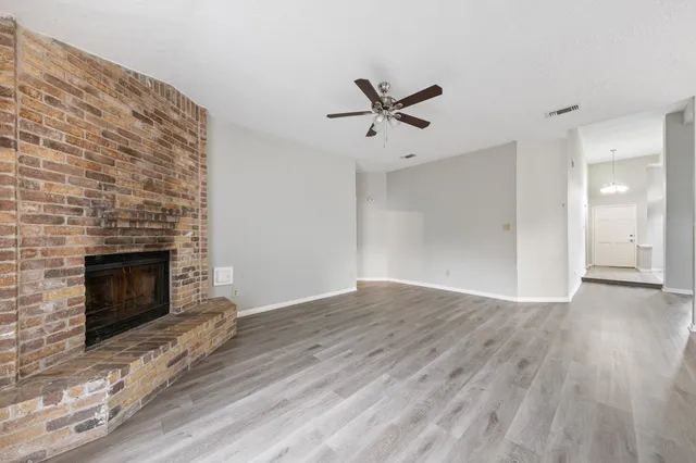 a view of empty room with wooden floor and fireplace