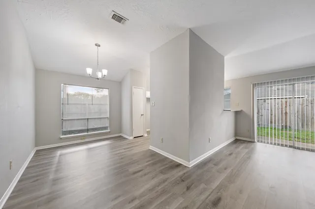an empty room with wooden floor and window