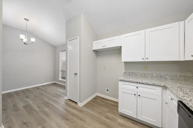 a kitchen with granite countertop white cabinets and white appliances