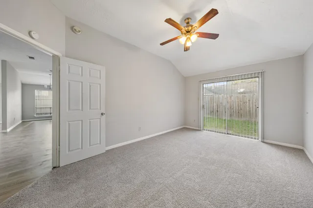 an empty room with fan and windows