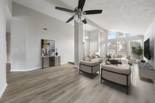 a living room with furniture flat screen tv and a large window