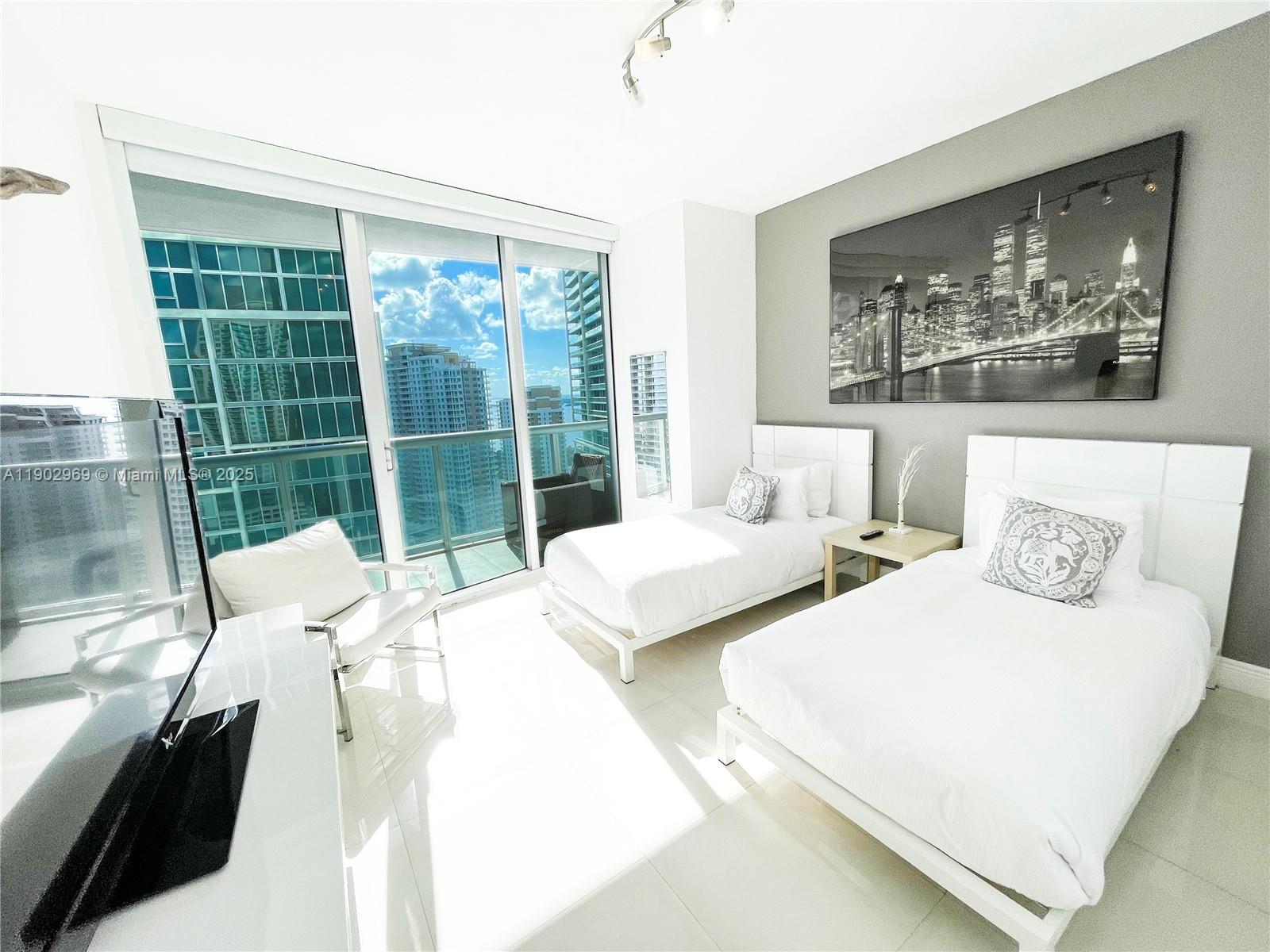 485 Brickell Avenue, Unit 2602 Miami, FL 33131 - Photo 12 of 19 a bedroom with bed and glass window