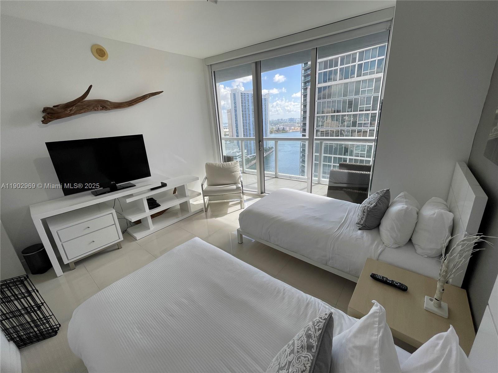 485 Brickell Avenue, Unit 2602 Miami, FL 33131 - Photo 13 of 19 a bedroom with a bed and a flat screen tv