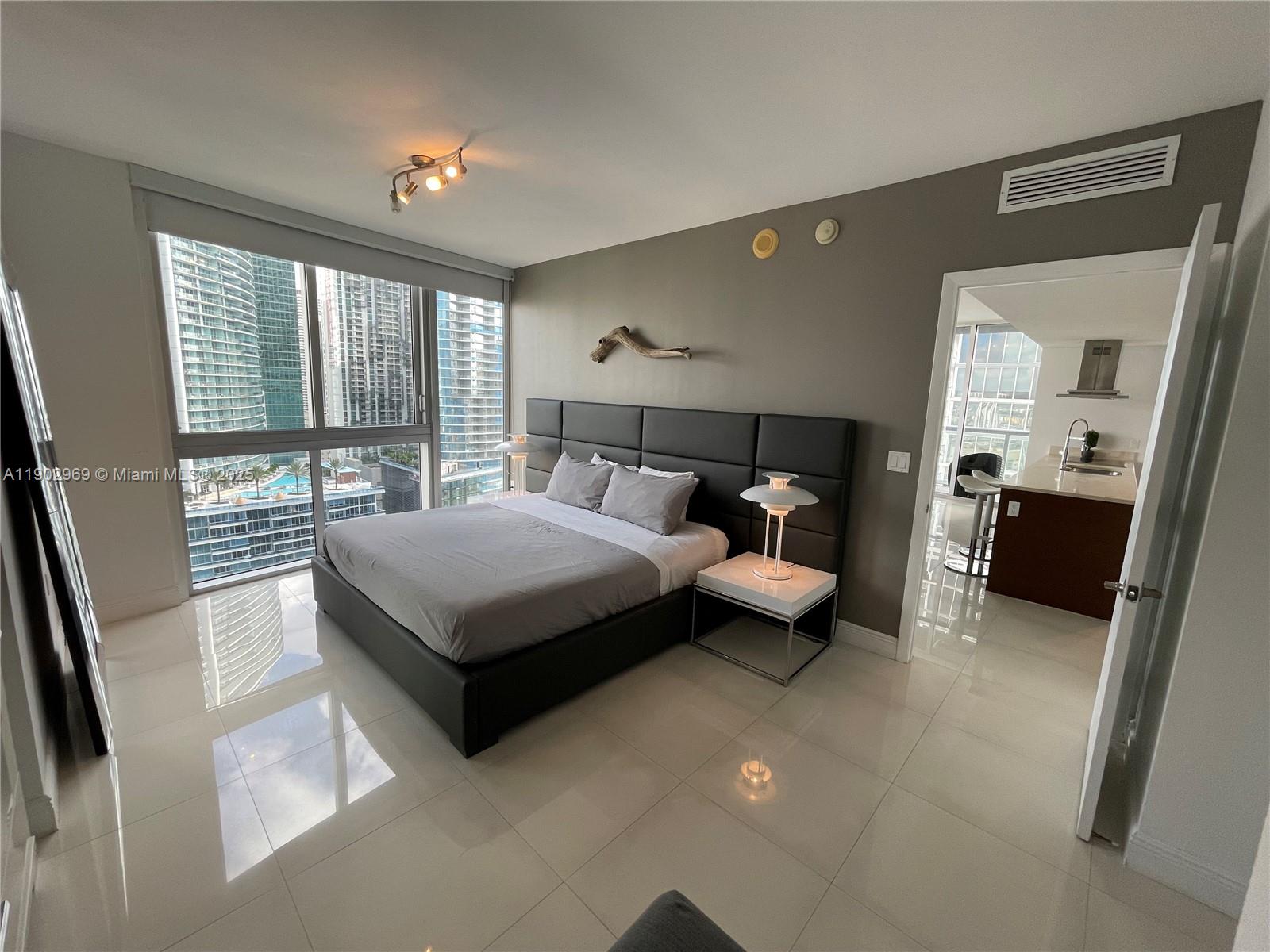 485 Brickell Avenue, Unit 2602 Miami, FL 33131 - Photo 8 of 19 a bedroom with a bed and large window