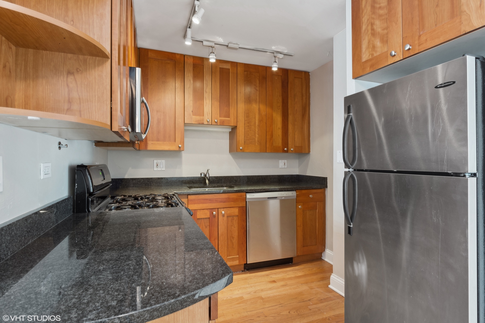 4144 North Sheridan Road, Unit 205 Chicago, IL 60613 - Photo 11 of 18 a kitchen with stainless steel appliances granite countertop a refrigerator stove and sink
