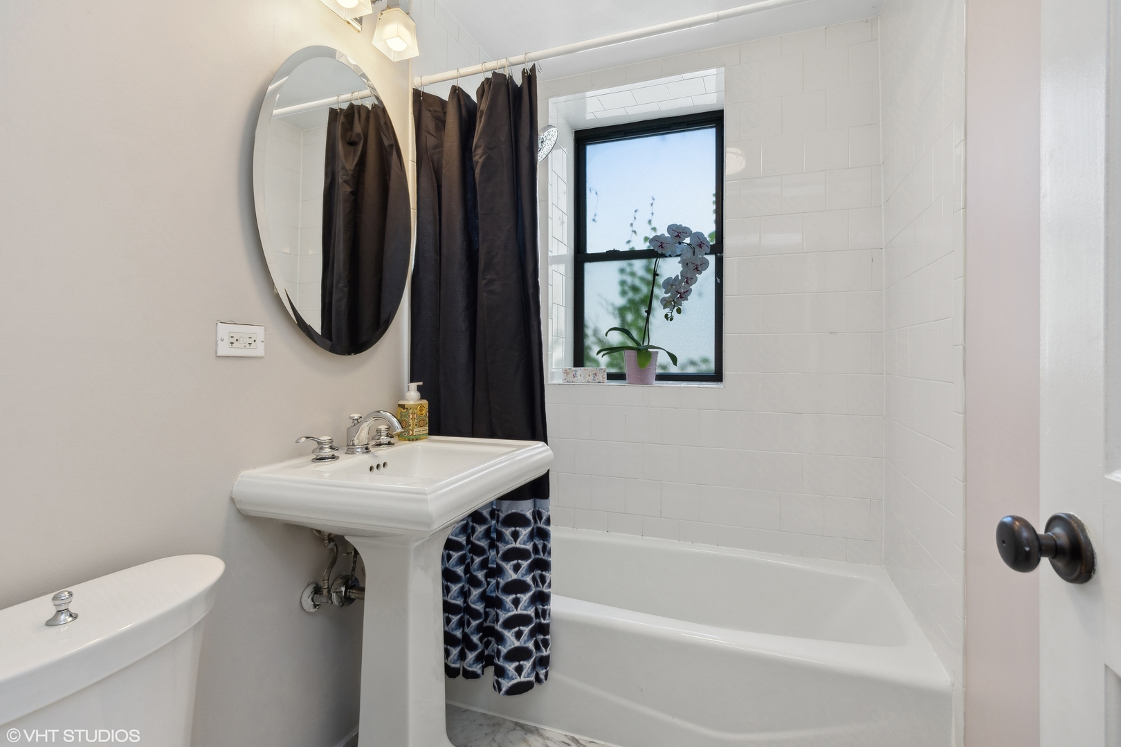 4144 North Sheridan Road, Unit 205 Chicago, IL 60613 - Photo 14 of 18 a bathroom with a sink a toilet and a mirror