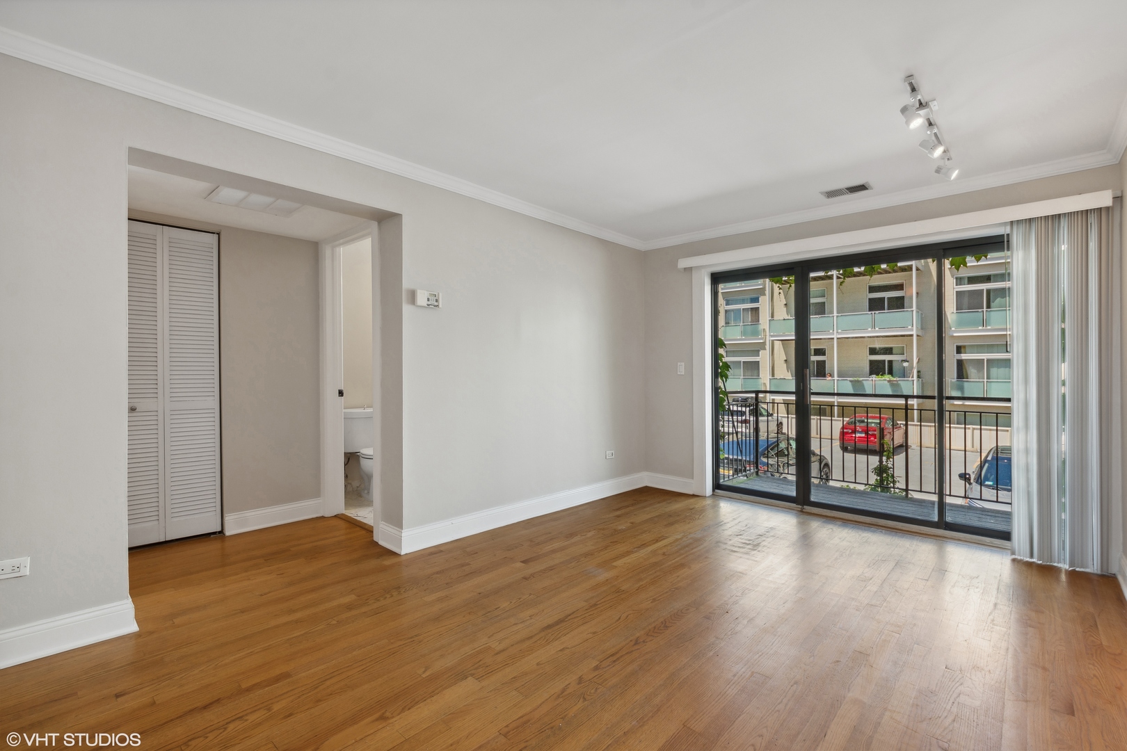 4144 North Sheridan Road, Unit 205 Chicago, IL 60613 - Photo 9 of 18 a view of an empty room with wooden floor and a window