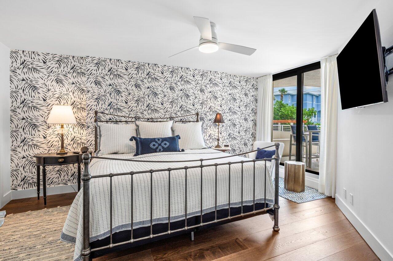 176 Helios Drive, Unit 104 Jupiter, FL 33477 - Photo 12 of 59 a bed sitting in a spacious bedroom next to a window