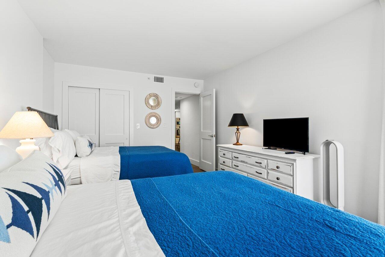 176 Helios Drive, Unit 104 Jupiter, FL 33477 - Photo 34 of 59 a bedroom with a bed and a flat screen tv