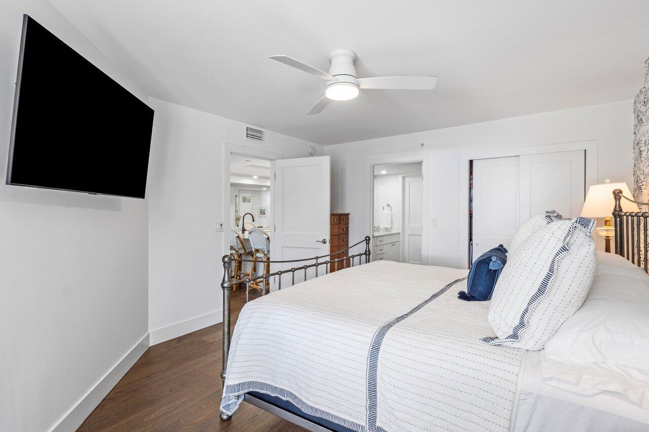 176 Helios Drive, Unit 104 Jupiter, FL 33477 - Photo 35 of 59 a bedroom with a bed and a flat screen tv