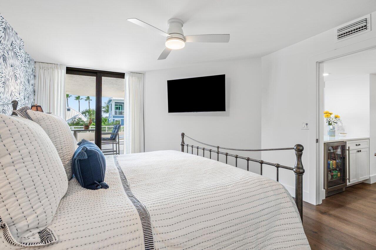 176 Helios Drive, Unit 104 Jupiter, FL 33477 - Photo 36 of 59 a bedroom with a bed tv and a window
