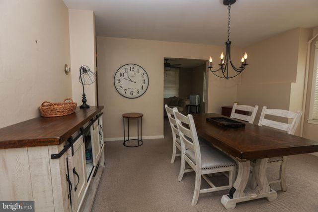 a view of a dining room with furniture and a chandelier