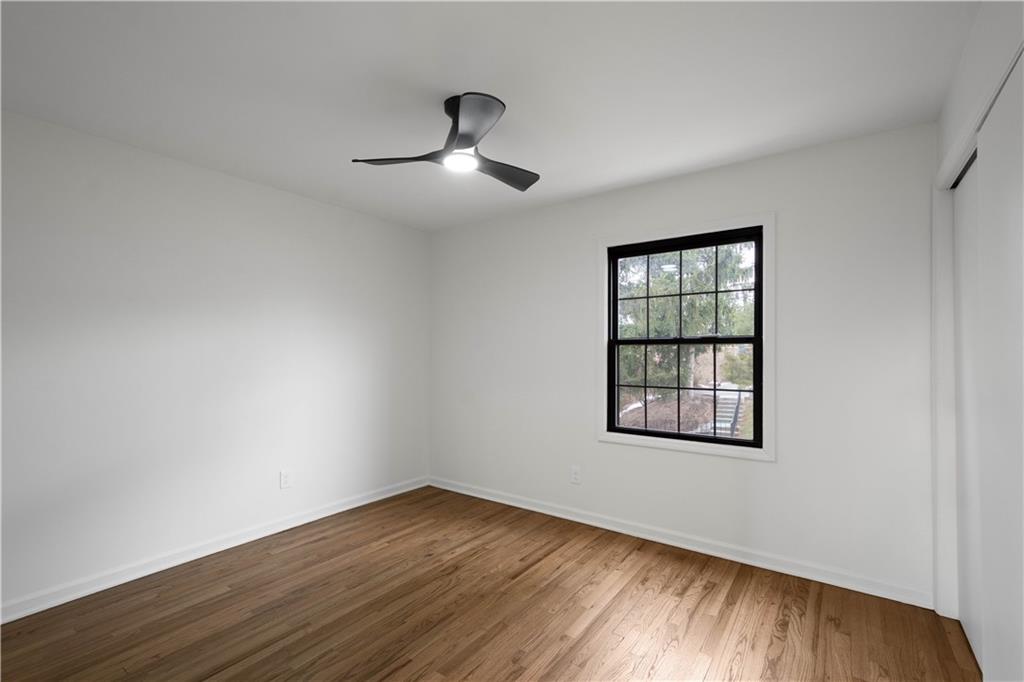 139 Community Court Pittsburgh, PA 15205 - Photo 18 of 32 an empty room with wooden floor chandelier fan and windows