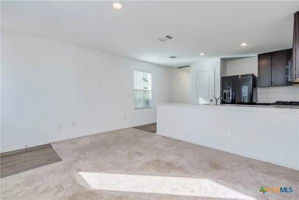 a view of a kitchen with a sink and a refrigerator