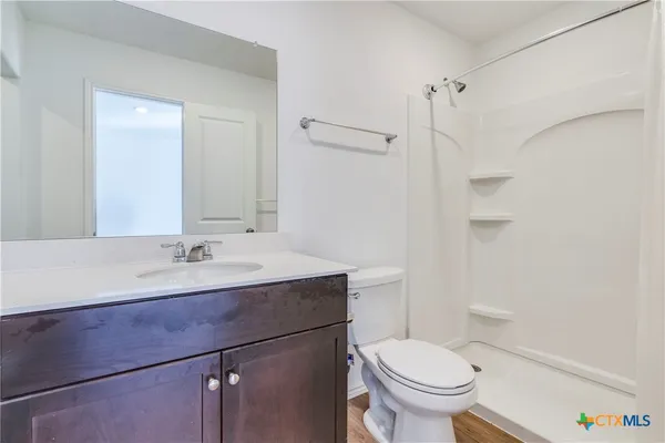 a bathroom with a sink toilet vanity and shower