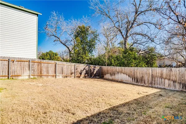a view of backyard and wooden fence