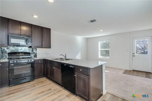 a kitchen with stainless steel appliances granite countertop a sink stove and oven