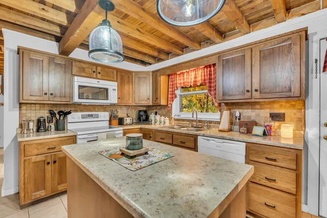 a kitchen with stainless steel appliances granite countertop a sink a stove and cabinets