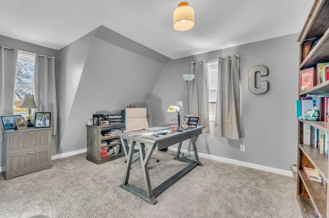 a view of a workspace with furniture and a window