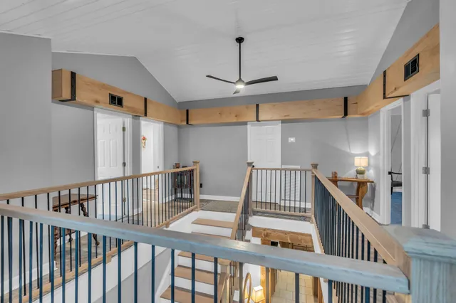 a view of staircase with lots of frames on wall and wooden floor