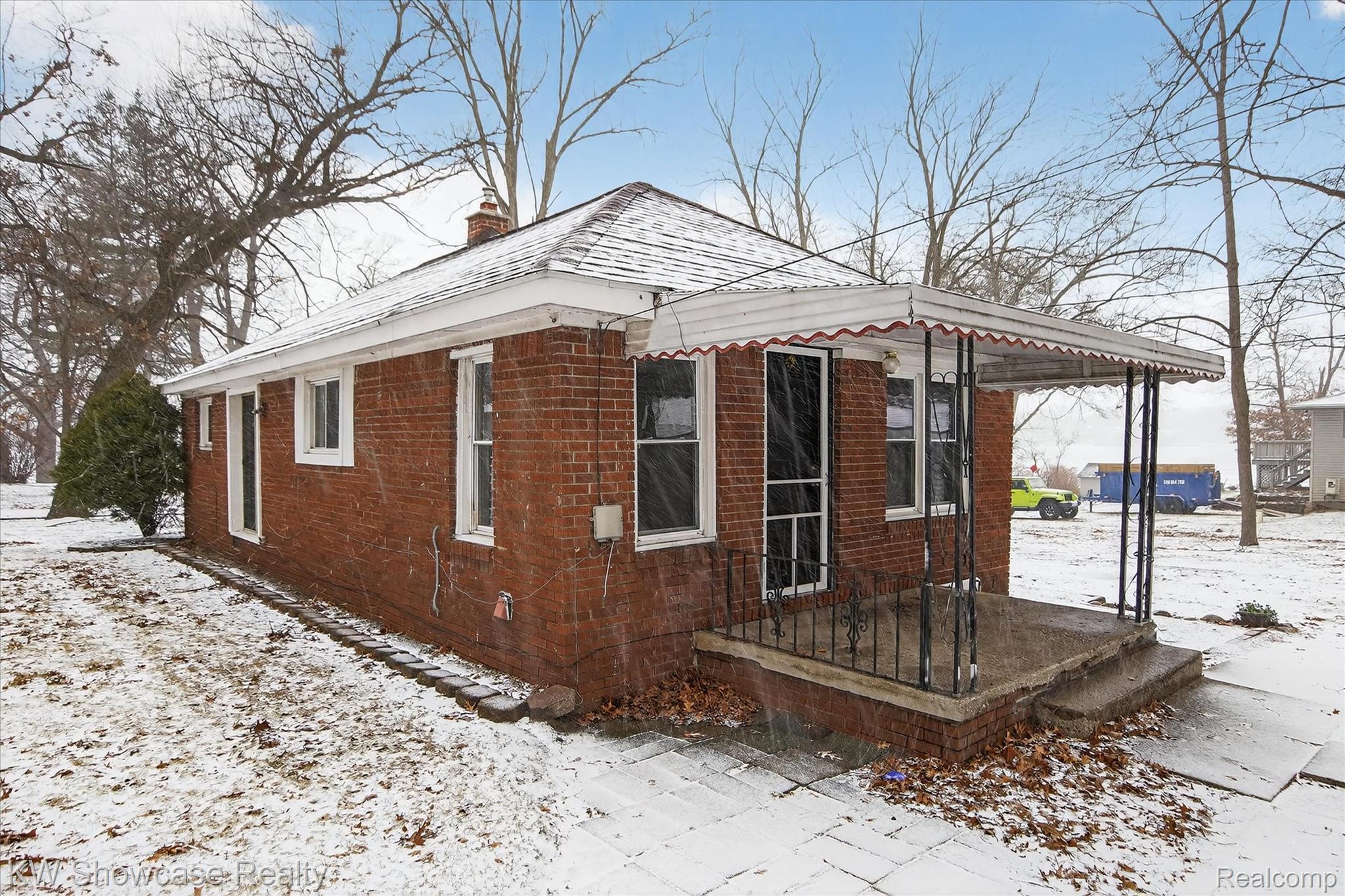 1860 Ladd Road Walled Lake, MI 48390 - Photo 28 of 48 View of snow covered exterior with a chimney and brick siding