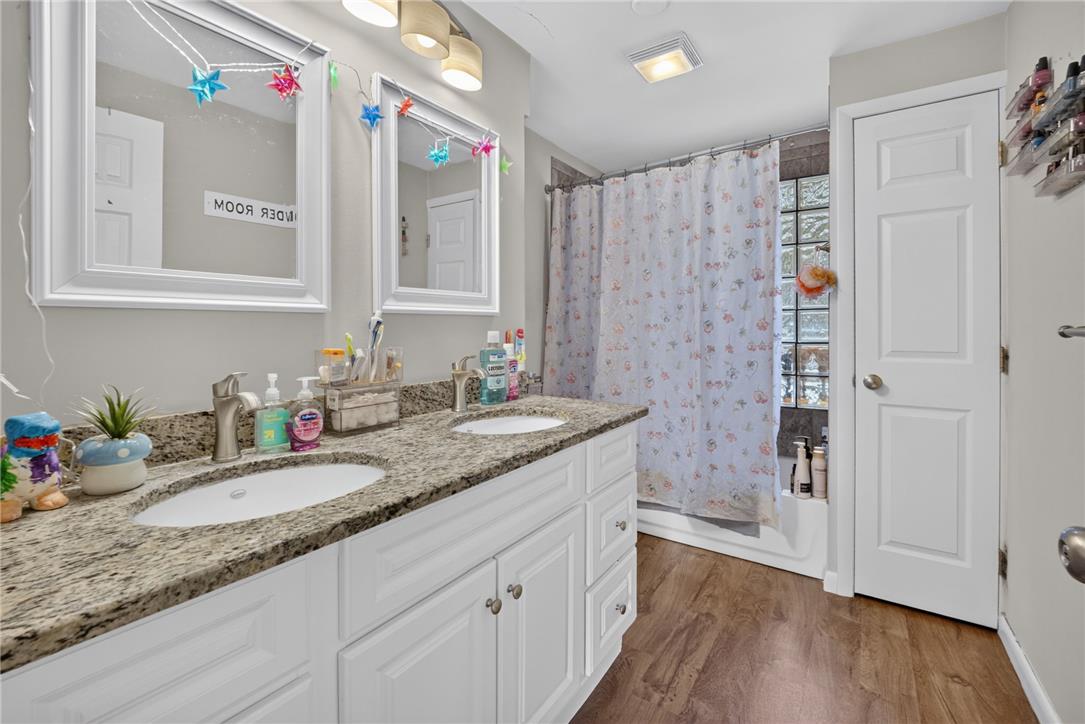 3123 Orefield Road Allentown, PA 18104 - Photo 22 of 39 Double vanity with granite counters and rich wood flooring offers a functional, stylish bathroom space.