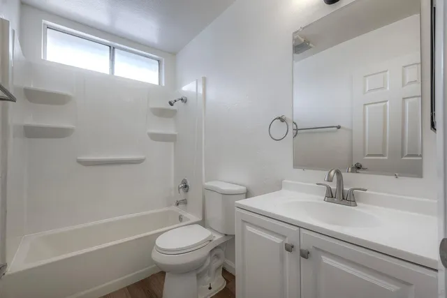 a view of an empty room with wooden floor and closet