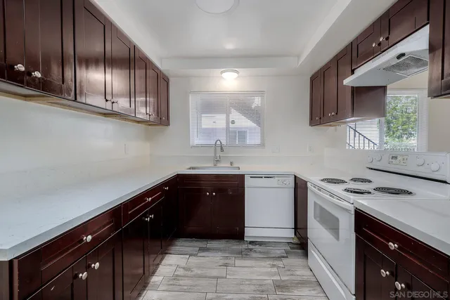a kitchen with stainless steel appliances sink a stove and cabinets